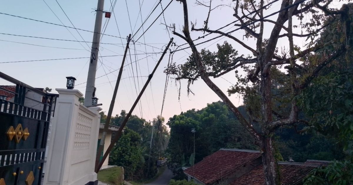 Tiang listrik miring dan kabel tegangan tinggi menjuntai di jalan Kampung Pangradin 2, Jasinga, (Dede Surya/PortalBogor)